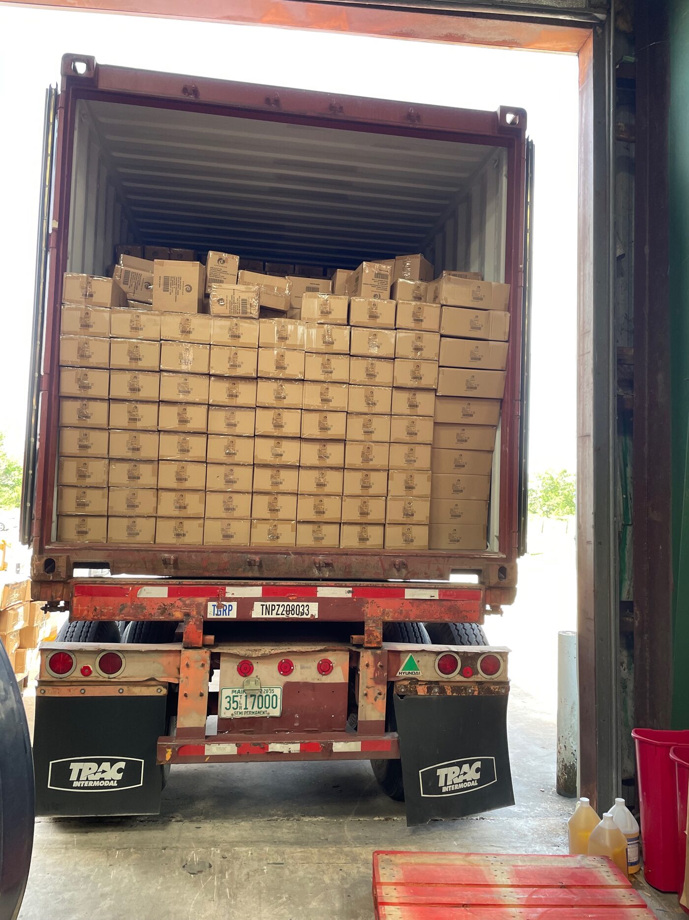 Shipping container full of cartons backed up to FlexPrep warehouse for devanning